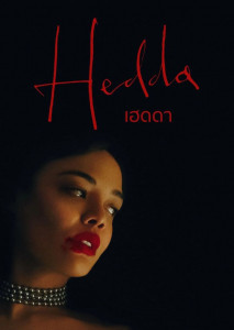 Hedda (2025) เฮดดา แสดงหญิงสาวในชุดหรูยืนกลางห้องมืด สื่อถึงความโดดเดี่ยว ความลับ และแรงปรารถนาที่ปะทุภายในใจ